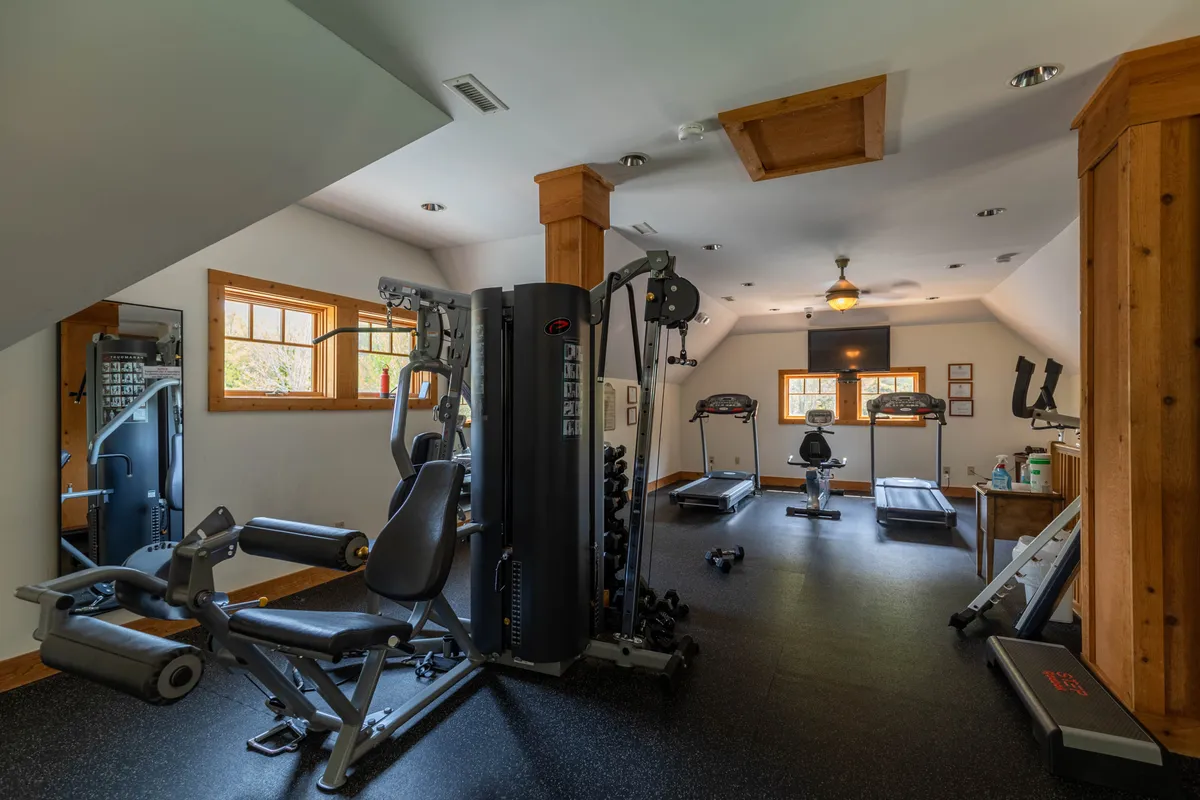 A bright, well-equipped fitness center filled with strength training machines, treadmills, free weights, and mirrored walls. Large windows bring in natural light, creating an invigorating atmosphere for workouts or group fitness sessions.