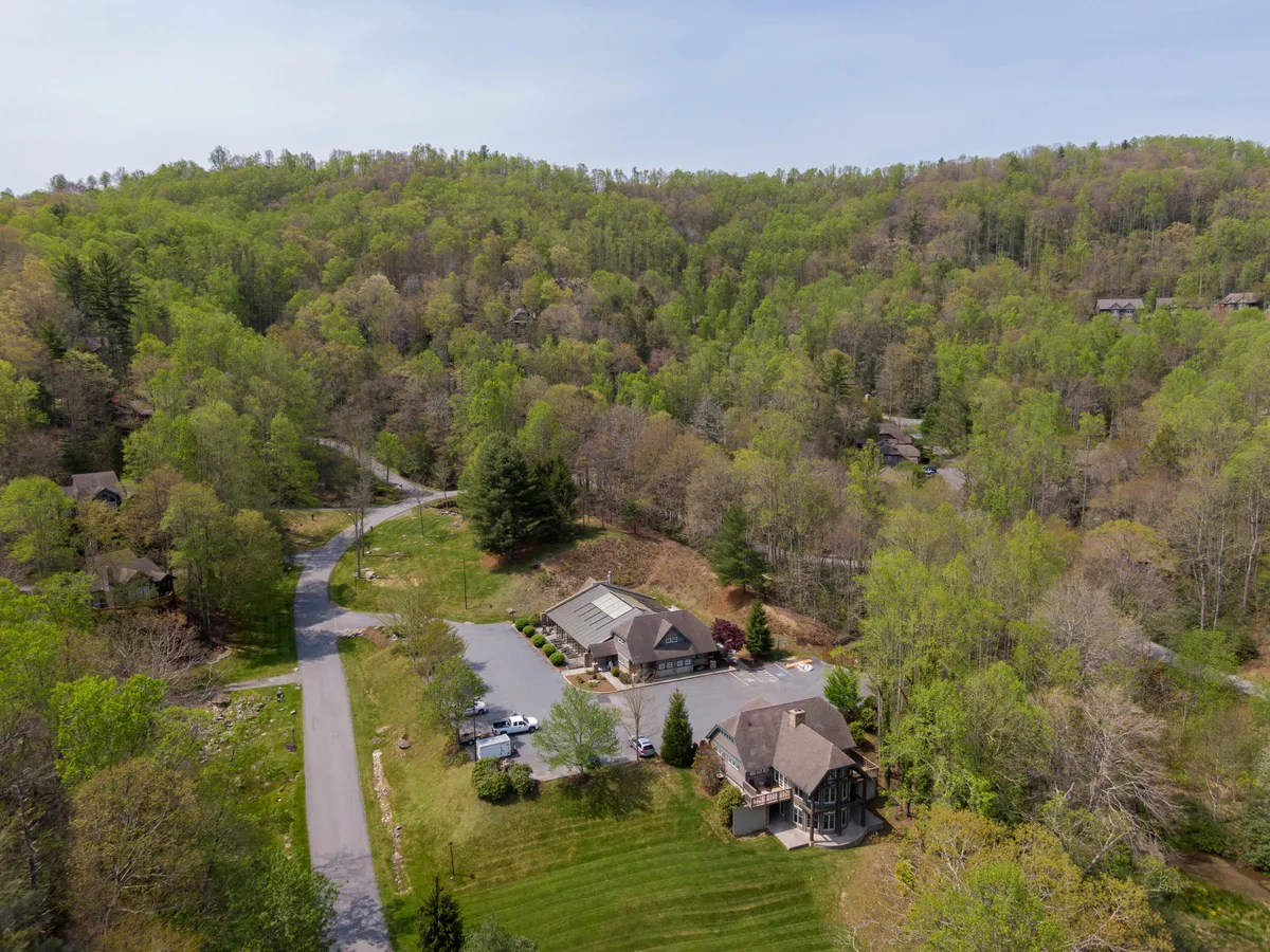 This image presents the main building of the resort, nestled among lush trees and bordered by winding roadways. The setting evokes a tranquil mountain atmosphere, with the verdant landscape and well-maintained grounds inviting exploration and outdoor activities.